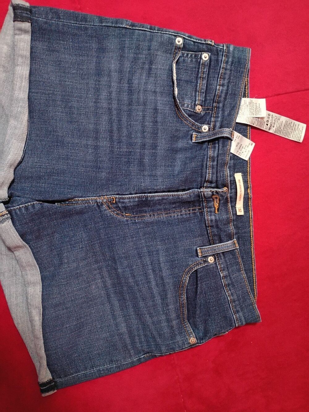 These are Levi's women's mid-length denim shorts, featuring a cuffed hem and